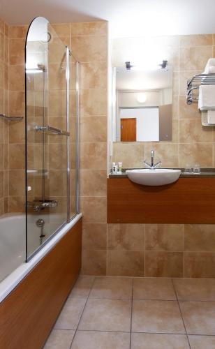 a bathroom with a tub and a sink and a shower at Wigan Oak Hotel by Belvilla in Wigan