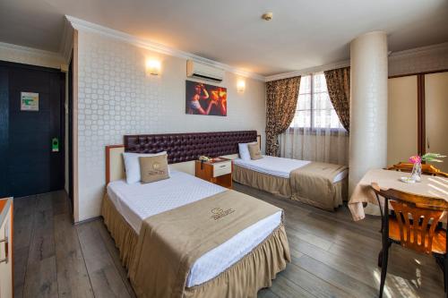 
a hotel room with two beds and a television at Kozan City Hotel in İzmir
