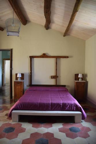 a bedroom with a purple bed in a room at Palazzo del Diplomatico in Belmonte Calabro