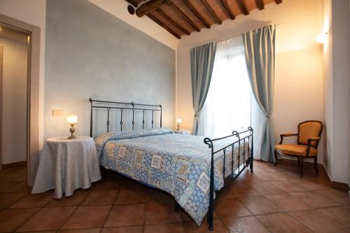 una camera con letto, tavolo e finestra di Casa Siena Vallepiatta a Siena
