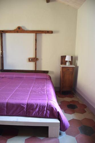 a bedroom with a purple bed and a table at Palazzo del Diplomatico in Belmonte Calabro