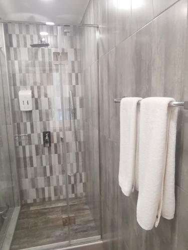 a bathroom with a shower with white towels at Bonjour Boutique Hotel Yerevan in Yerevan