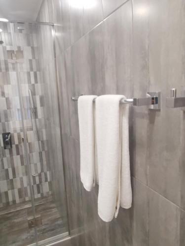 a bathroom with white towels hanging on a shower at Bonjour Boutique Hotel Yerevan in Yerevan