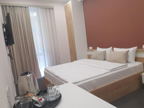 a hotel room with two beds and a television at Bonjour Boutique Hotel Yerevan in Yerevan