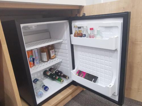 a refrigerator with its door open with drinks in it at Bonjour Boutique Hotel Yerevan in Yerevan