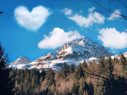 a mountain covered in snow and clouds in the sky at Agriturismo Ai Castioni in Molveno