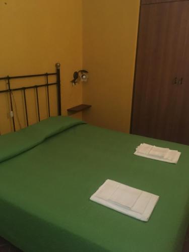 MontaleにあるAppartamento Margheritaの緑のベッド(シーツ2枚、タオル付)