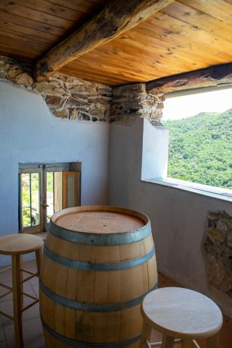 a room with a barrel and two stools and a window at Palazzo del Diplomatico in Belmonte Calabro
