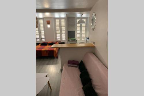 Una sala de estar con un sofá y un dormitorio. en Appartement complet, hyper centre d’Auxerre., en Auxerre