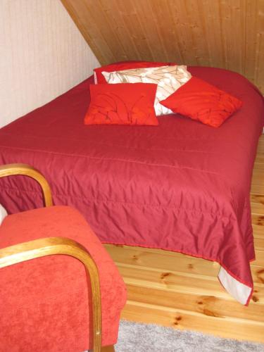 a bedroom with a bed with red sheets and pillows at Tunturikoivu in Ylläsjärvi