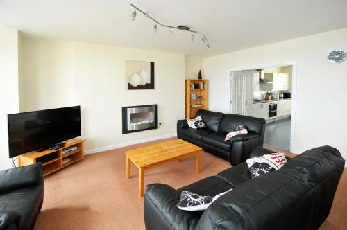 a living room with a couch and a tv at Cunard Apartments in Douglas