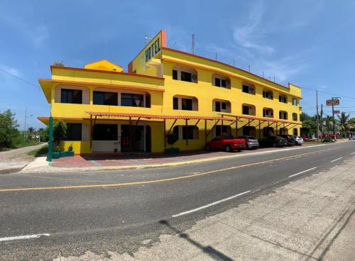 a yellow building on the side of a street at Hotel Sociedad y Maristas in Tecolutla
