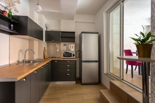 a kitchen with a stainless steel refrigerator and a table at Hostel Denica in Skopje