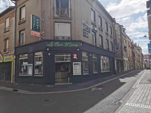 a building with a store on the side of a street at Hotel Le Bon Moine in Reims