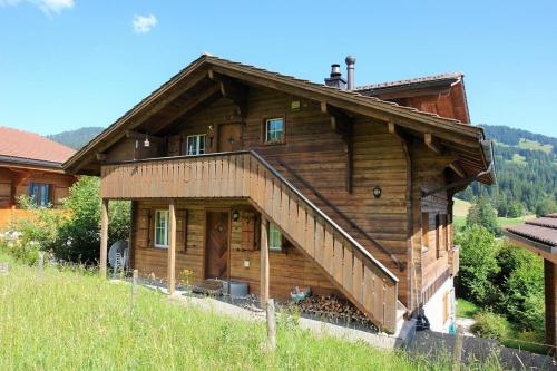 a large wooden house with a staircase in front of it at Chalet Mutzli in Gstaad