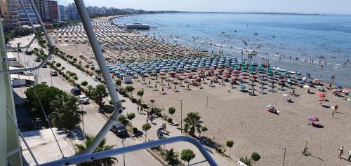 a beach with many umbrellas and people on it at Apartment Sea View in Shëngjin