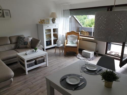 een woonkamer met een bank en een tafel bij Andinas Fewo - Natur pur - Wunderschöner Ausblick in Winterberg