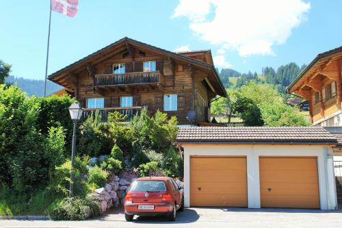 une voiture garée devant une maison avec garage dans l'établissement Chalet Mutzli, à Gstaad