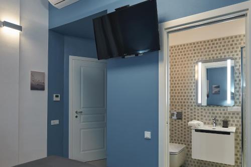 7 HEAVEN Elegant Rooms KRAKÓW Old Town في كراكوف: حمام بجدران زرقاء ومغسلة ومرحاض