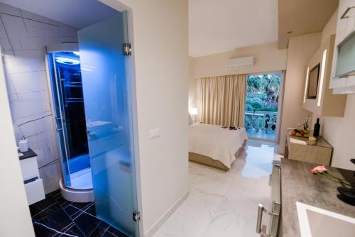 łazienka z prysznicem i łóżko w pokoju w obiekcie Stefanos Resort w mieście Mesongi