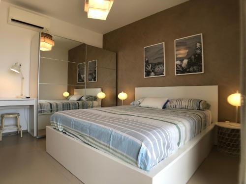 マリーナ・ディ・ラグーザにあるVista Mare Apartment con parcheggio privatoのベッドルーム(大型ベッド1台、鏡付)