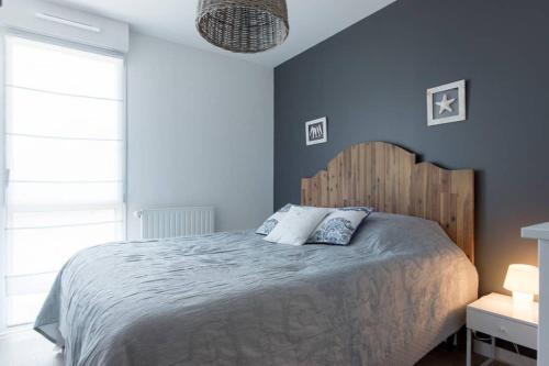 een slaapkamer met een groot bed met blauwe muren bij Appartement 4 étoiles bord de plage et parking Chez Suzette in Saint-Malo