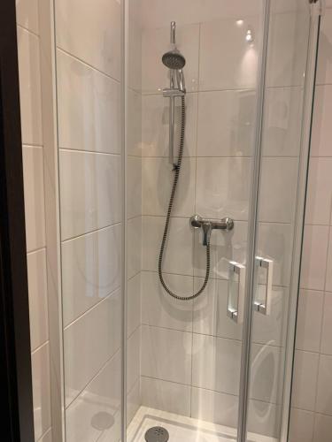 a shower stall with a glass door with a shower at Apartament Abrahama 40 in Gdynia