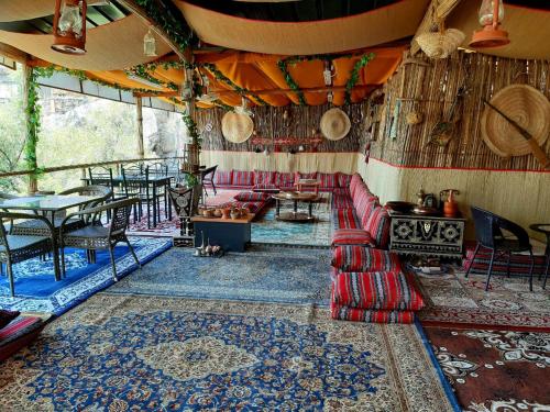 a room with a couch and a table and chairs at Misfah Heritage House in Misfāh