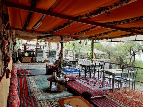 an outdoor patio with tables and chairs and a grill at Misfah Heritage House in Misfāh
