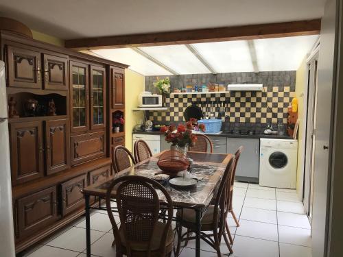 une cuisine avec une table et des chaises dans une cuisine dans l'établissement chambre d'hotes chez christiane, à Lourdes