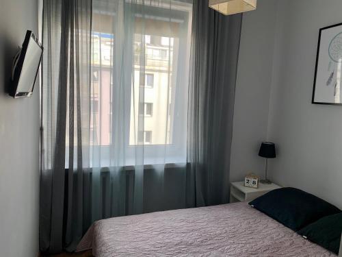 a bedroom with a bed and a large window at Apartament Abrahama 40 in Gdynia