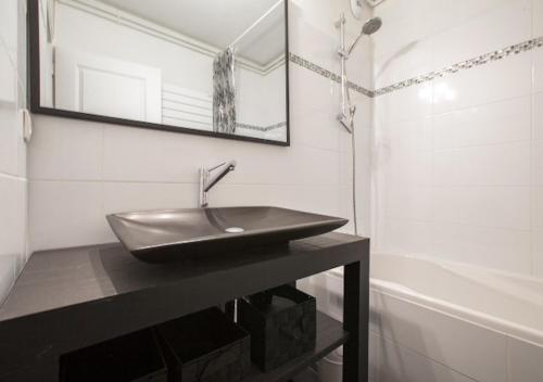 a bathroom with a sink and a mirror and a tub at Appartement 4 personnes (+1) LES 2 ALPES in Mont-de-Lans