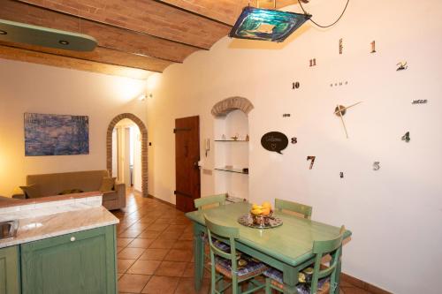 uma cozinha e sala de jantar com uma mesa verde em Casa Siena Vallepiatta em Siena