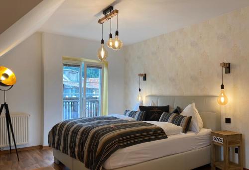 a bedroom with a bed and a window and lights at Club Alpenresidenz Gastein in Bad Gastein