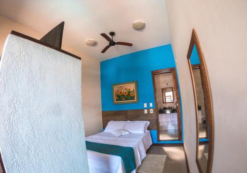 1 dormitorio con 1 cama y ventilador de techo en Pousada Larissa, en Paraty