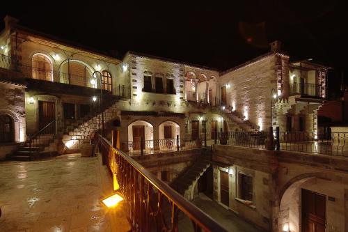 an old building with stairs and lights at night at Harman Cave Hotel in Goreme