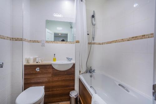 a bathroom with a sink and a tub and a toilet at The Talbot Hotel, Oundle , Near Peterborough - The Coaching Inn Group in Oundle
