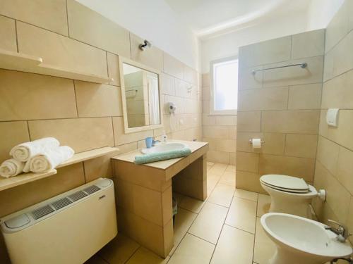 a bathroom with a sink and a toilet and a mirror at Casa Vacanze Eufemia in Giurdignano