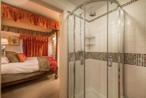 a bathroom with a shower and a bed in a room at The Talbot Hotel, Oundle , Near Peterborough in Oundle