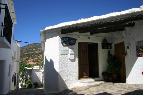 Apartamentos y Casas Rurales Las Terrazas de la Alpujarra في بوبيون: مبنى ابيض مع باب على شارع