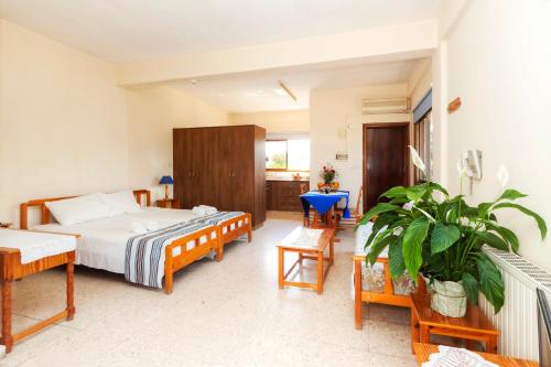 a bedroom with a bed and a table and chairs at Follow The Sun Hotel Apartments in Polis Chrysochous