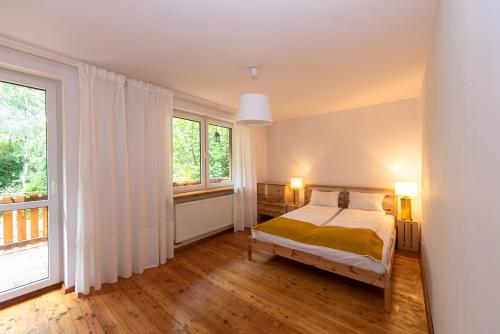 um quarto com uma cama e uma grande janela em Secret Garden Residence em Paszkówka