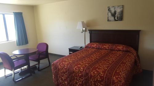 a hotel room with a bed and a table and chairs at Safari Inn Motel in Winston