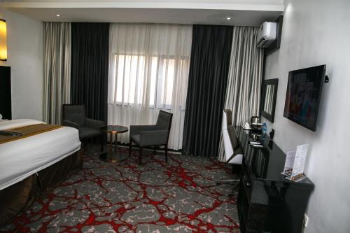 ein Hotelzimmer mit einem Bett, einem Tisch und Stühlen in der Unterkunft GreenPoint Hotel in Lagos