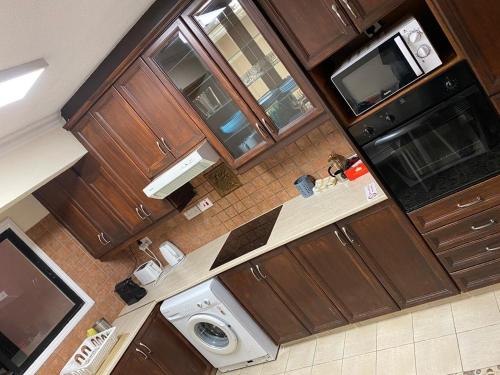 - une vue sur la cuisine avec des placards en bois dans l'établissement City Comfort Rooms, à Larnaka