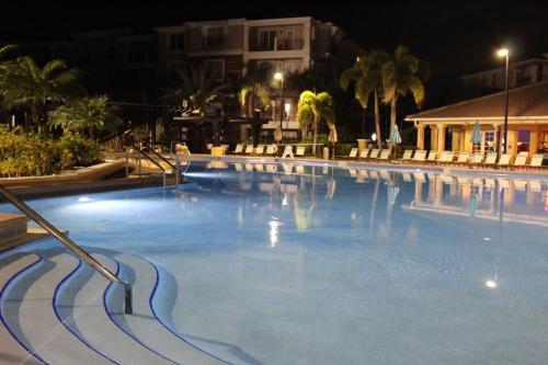 a large swimming pool at night at Viz Cay Apartment 202 in Orlando