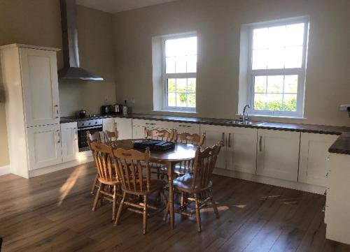 cocina con mesa y sillas en una habitación en Grannan School, Trillick, Fermanagh and Omagh, Tyrone en Trillick