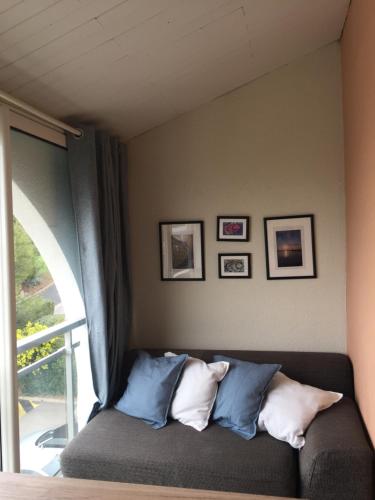 - un canapé avec des oreillers à côté d'une fenêtre dans l'établissement Vue imprenable avec piscine à Sète, à Sète