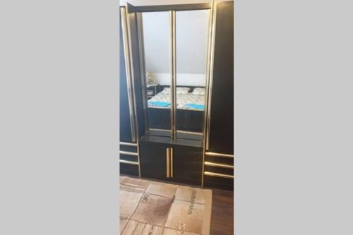 a black and gold cabinet with a mirror at APARTMANI Ricci R 1 in Veliko Gradište