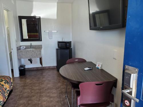 Cette petite chambre comprend une table et un lavabo. dans l'établissement High Desert Inn, à Hesperia